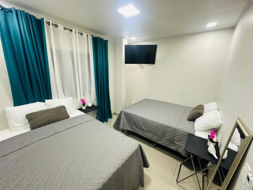 a hotel room with two beds and a mirror at El Mirador A2 in Santa Rosa de Copán