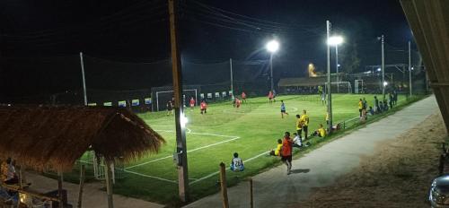 a group of people on a tennis court at night at VicaWorld in Prathai