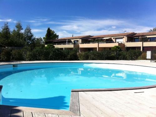 une grande piscine bleue devant un immeuble dans l'établissement Mas de Constance, à Aigues-Mortes