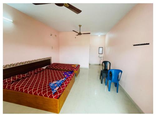 a bedroom with a bed and two blue chairs at THIRUNALLAR S A RESIDENCY in Thirunallar