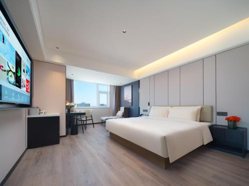 a hotel room with a bed and a flat screen tv at Atour Hotel Zhengzhou Erqi Plaza David City in Zhengzhou