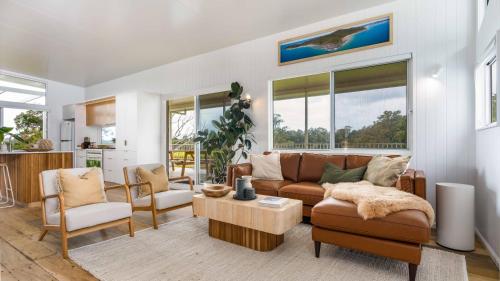 a living room with a couch and a table at 'Rail Trail Cottage'-Artisan rural Home 5 mins to pristine beach in Mooball