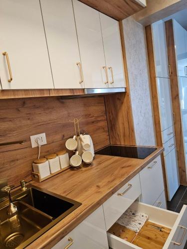 a kitchen with white cabinets and a sink at Apartman KING CENTAR in Vrnjačka Banja