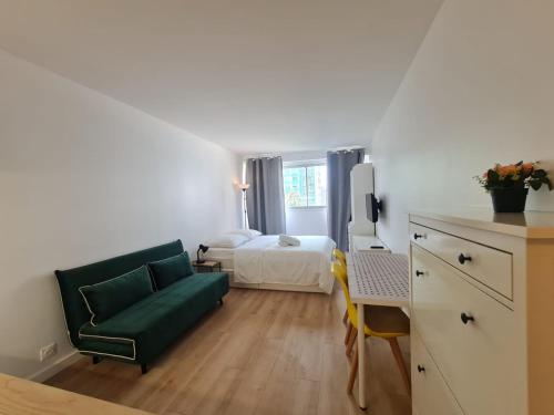 une chambre avec un lit, un canapé et un bureau dans l'établissement Super studio Paris La Défense, à Courbevoie