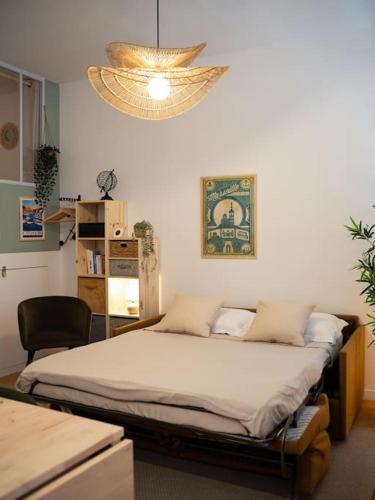 une chambre avec un lit et un lustre dans l'établissement La Cigale - Superbe Studio au coeur du Panier - Les Frères de la Loc', à Marseille