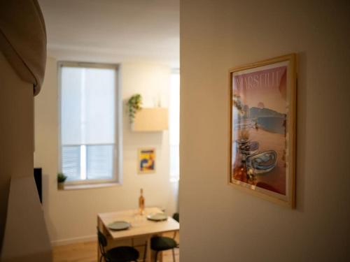 une chambre avec une table et une photo sur le mur dans l'établissement La Cigale - Superbe Studio au coeur du Panier - Les Frères de la Loc', à Marseille