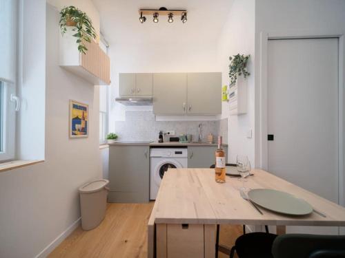 une cuisine blanche avec un comptoir et une table dans l'établissement La Cigale - Superbe Studio au coeur du Panier - Les Frères de la Loc', à Marseille