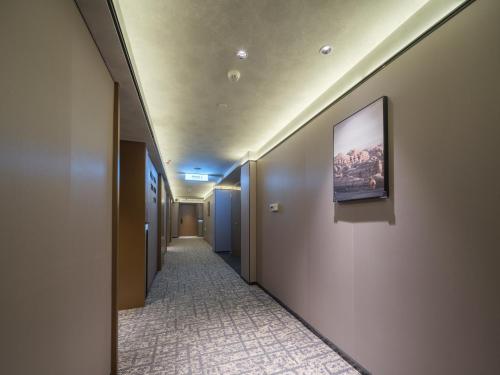 a hallway with a painting on the wall at Atour Hotel Zhengzhou Erqi Plaza David City in Zhengzhou