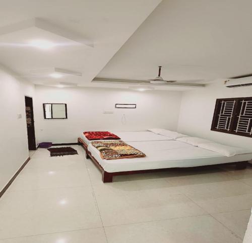 a white room with a large bed in it at Minnal Residency in kāraikāl