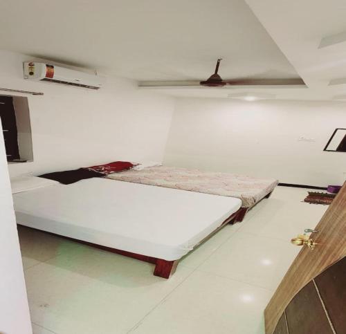 a bed in a room with a white wall at Minnal Residency in kāraikāl