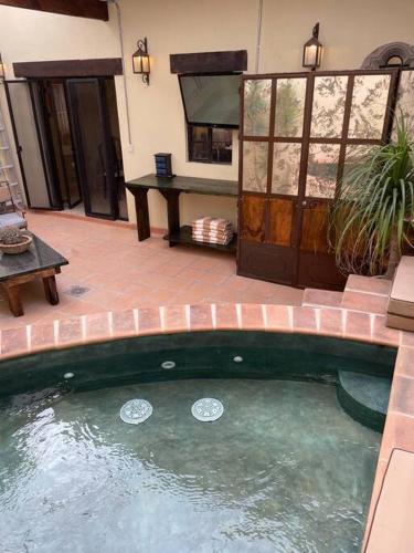 a pool of water in a patio with a table at Casa Vallejo in San Miguel de Allende