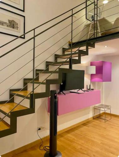 a living room with a staircase with a tv at Loft Crocetta in Turin