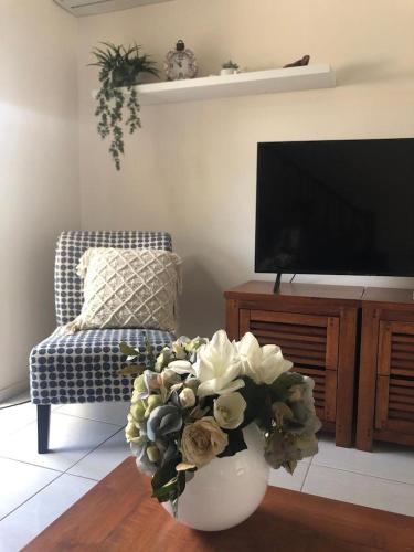 a living room with a vase with flowers in it at Alroy Street 4/7 in Aitkenvale