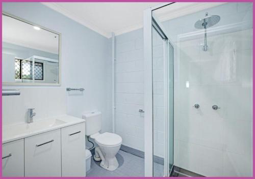 a bathroom with a shower and a toilet and a sink at Queens Road 14/80 in Aitkenvale