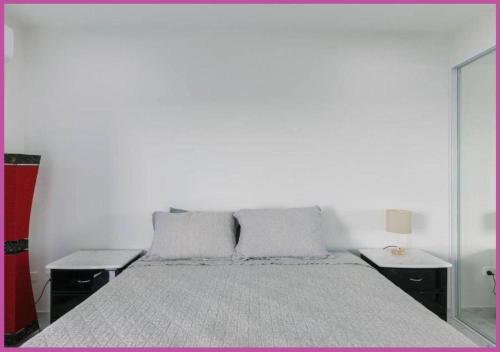 a white bedroom with a large bed with two pillows at Luxe On Duke in Stuart Park