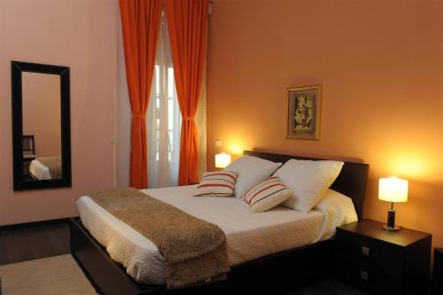 a bedroom with a bed with two pillows and a mirror at B&B Alexander in Rome