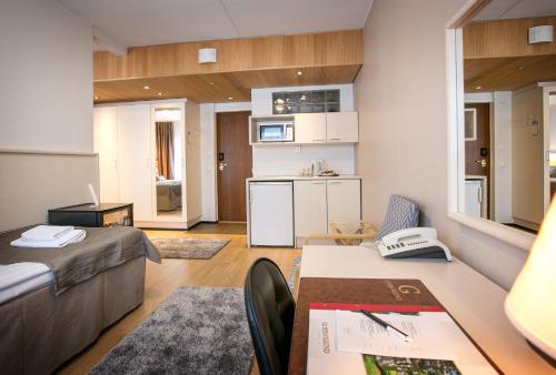 a living room with a couch and a table at Hotelli Gustavelund in Tuusula