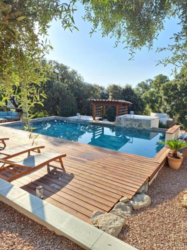 - une piscine avec une terrasse en bois et une table de pique-nique dans l'établissement Appartement Jardin et Piscine Les anges du maquis location Corse-du-Sud, à Conca