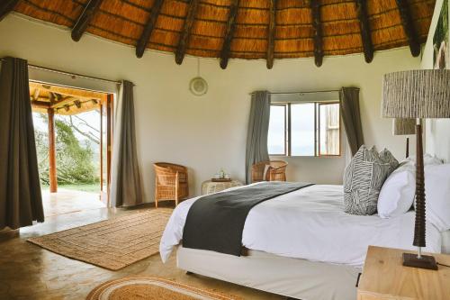 a bedroom with a bed and a table with a lamp at Makongo Hills Lodge in Magudu