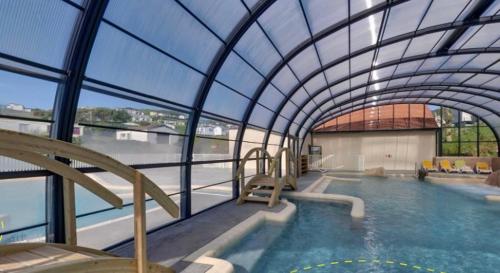 une grande piscine intérieure avec un plafond en verre dans l'établissement Calme proche de la mer, à Équihen-Plage