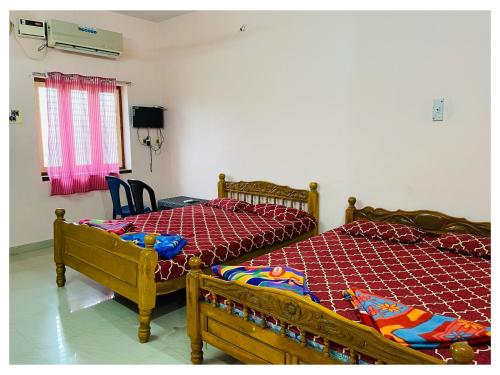two beds sitting next to each other in a room at THIRUNALLAR S A RESIDENCY in Thirunallar