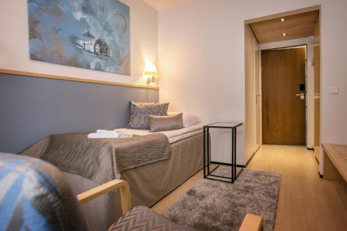 a small room with two beds and a door at Hotelli Gustavelund in Tuusula