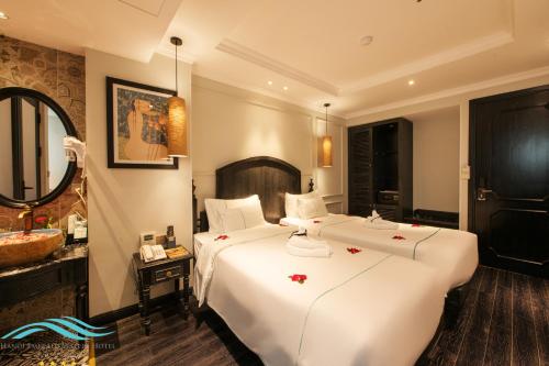 a hotel room with two beds and a mirror at Hanoi Emerald Waters Hotel Valley in Hanoi
