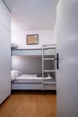 a room with two bunk beds and a door at MOOKI Mountain & Pool Gerlitzen Apartment in Kanzelhöhe