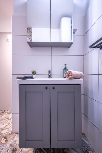 a bathroom with a sink and a white cabinet at MOOKI Mountain & Pool Gerlitzen Apartment in Kanzelhöhe