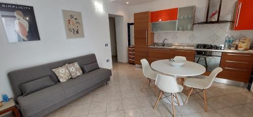 a living room with a couch and a table and chairs at Casa Vacanze - VIOLA HOUSE by La Casa di Viola - Marsala in Marsala