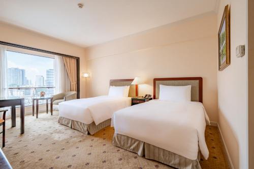 a hotel room with two beds and a window at Lotte Hotel Saigon in Ho Chi Minh City