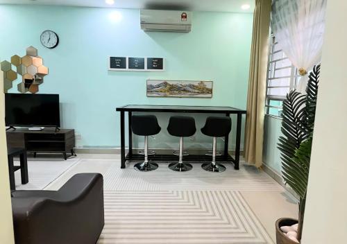 a living room with a black table and two stools at Homestay Pulau Pinang Urban Sky Guesthouse in Bayan Lepas