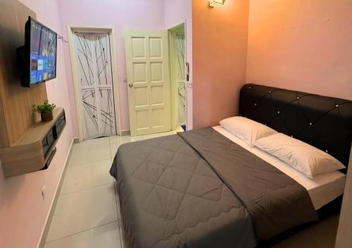a bedroom with a bed and a flat screen tv at Homestay Pulau Pinang Urban Sky Guesthouse in Bayan Lepas