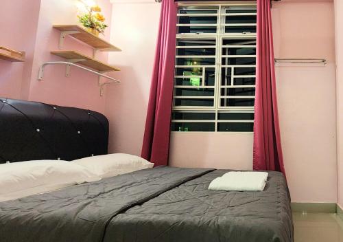 a bedroom with a bed and a window with pink curtains at Homestay Pulau Pinang Urban Sky Guesthouse in Bayan Lepas