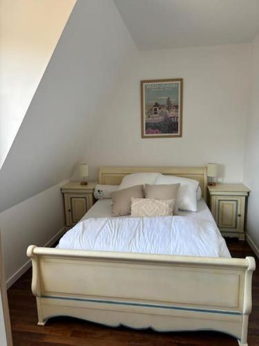 a bedroom with a white bed with two night stands at Séjour idyllique normand in Veules-les-Roses