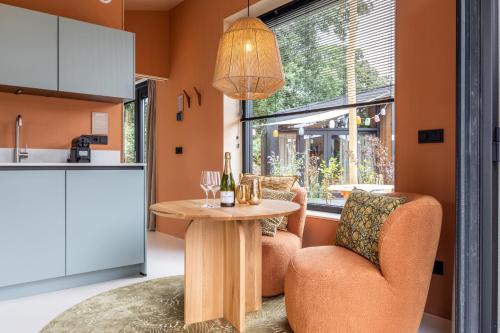 a kitchen and dining room with a table and chairs at Wellness Lodges x De IJsvogel in Voorthuizen