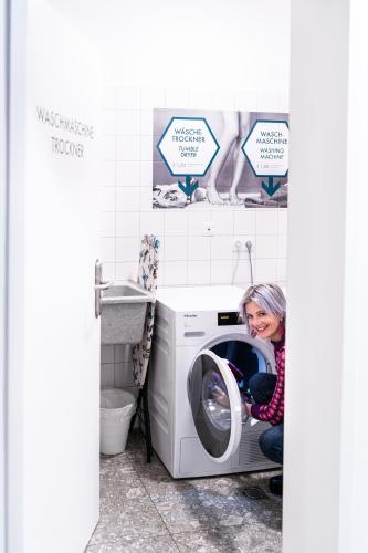 a woman sitting in a washing machine in a bathroom at Motel Schlafraum Schlüßlberg-Dein smartes Hotel-contactless check-in in Schlüßlberg
