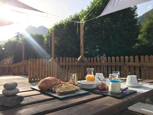 - une table en bois avec du pain et d'autres aliments dans l'établissement Chambre Verdaguere, à Auzat