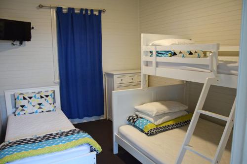 a bedroom with two bunk beds and a ladder at Rockleigh - Bring your own linen. in South West Rocks
