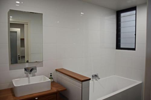 a bathroom with a sink and a bath tub at Rockleigh - Bring your own linen. in South West Rocks