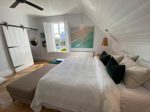 a bedroom with a large white bed and a window at Gable House in Geelong
