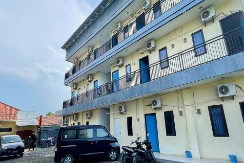 a building with a car parked in front of it at Richmond Guest House Cirebon RedPartner in Cirebon