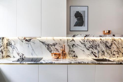 a kitchen with a marble counter top and a sink at Sophisticated Boutique Apartment in London