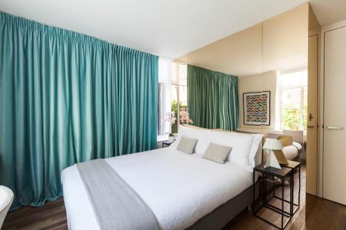 um quarto com uma cama grande e cortinas verdes em Sophisticated Boutique Apartment em Londres