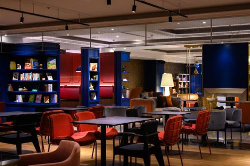 a restaurant with tables and chairs and bookshelves at Olah Poshtel Taichung Wenxin in Taichung