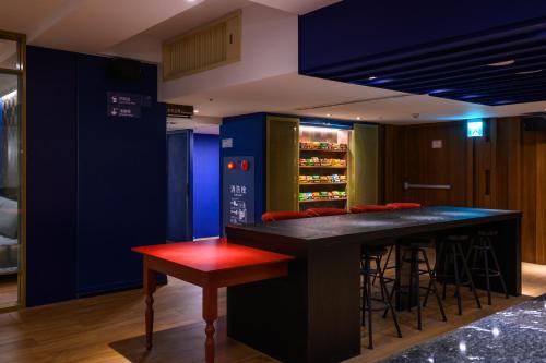 a bar in a room with a red stool at Olah Poshtel Taichung Wenxin in Taichung