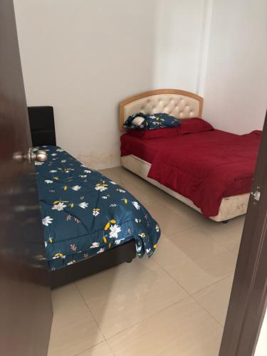 Un dormitorio con una cama y una colcha roja con pájaros. en Lily's Homestay, en Jerantut