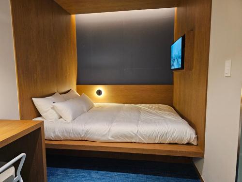 a bedroom with a bed with a television on it at Huga Inn in Seoul