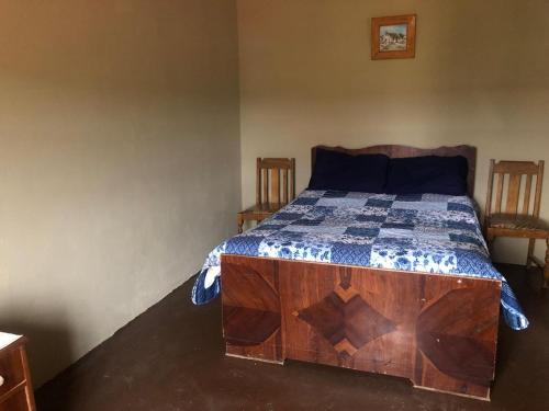 1 dormitorio con 1 cama con edredón azul y blanco en Groendeur Guesthouse, en Kotzesrus