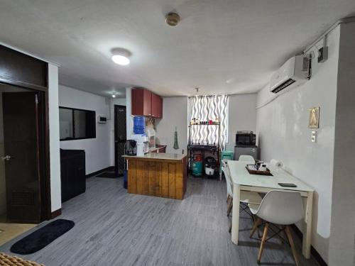 eine Küche und ein Wohnzimmer mit einem Tisch und einer Theke in der Unterkunft JM's Inn Lapu-lapu City in Lapu Lapu City